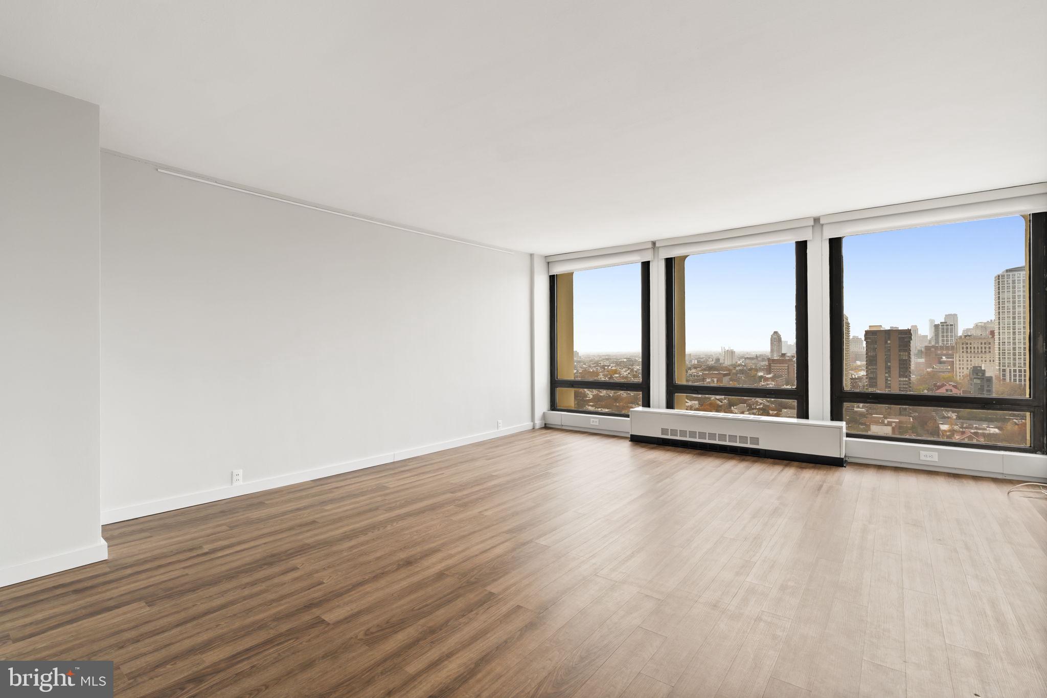 210 Locust Street, Unit 21E Philadelphia, PA 19106 - Photo 24 of 36 a view of an empty room with wooden floor and a window