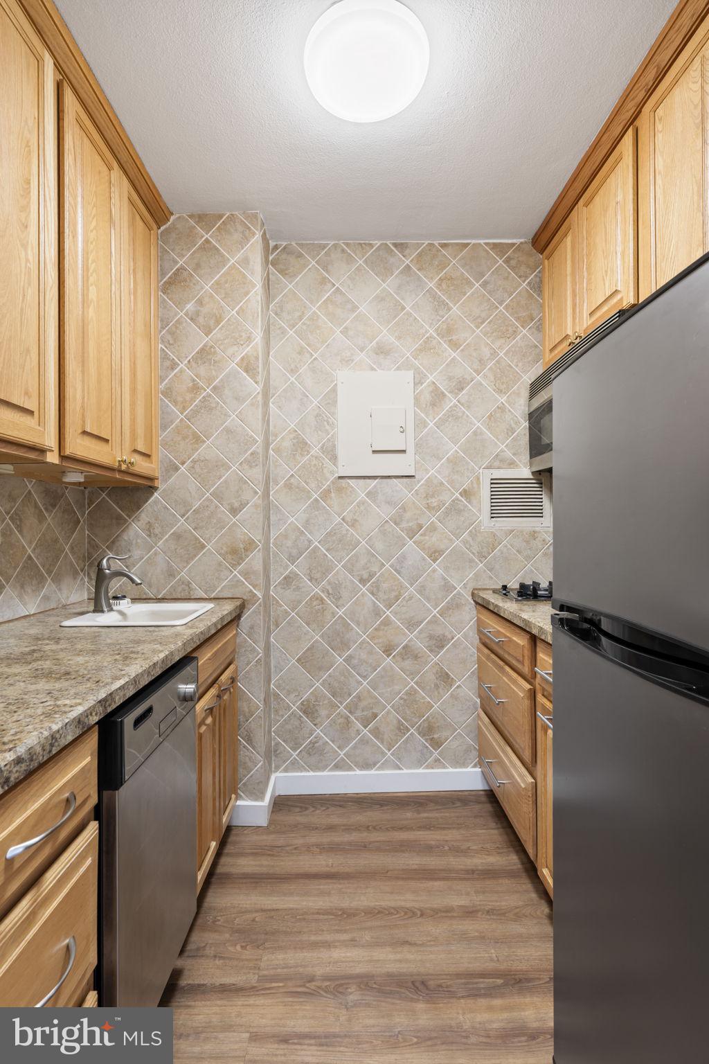 210 Locust Street, Unit 21E Philadelphia, PA 19106 - Photo 32 of 36 a kitchen with stainless steel appliances granite countertop a sink and a stove