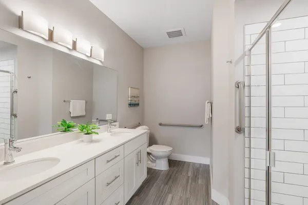 a bathroom with a double vanity sink toilet and shower