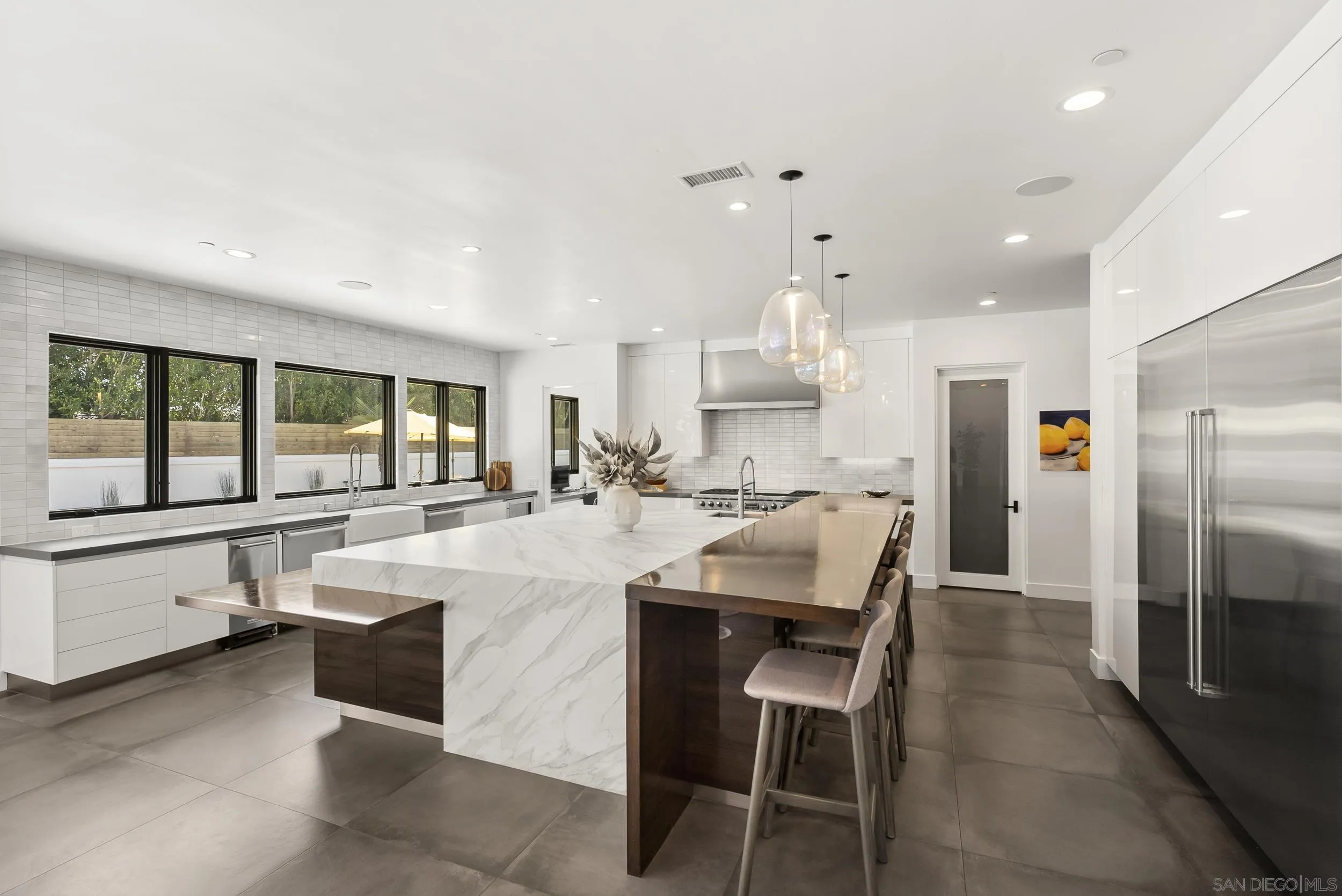 6850 Avenida De La Ronda Rancho Santa Fe, CA 92067 - Photo 12 of 40 a large white kitchen with a large window and stainless steel appliances