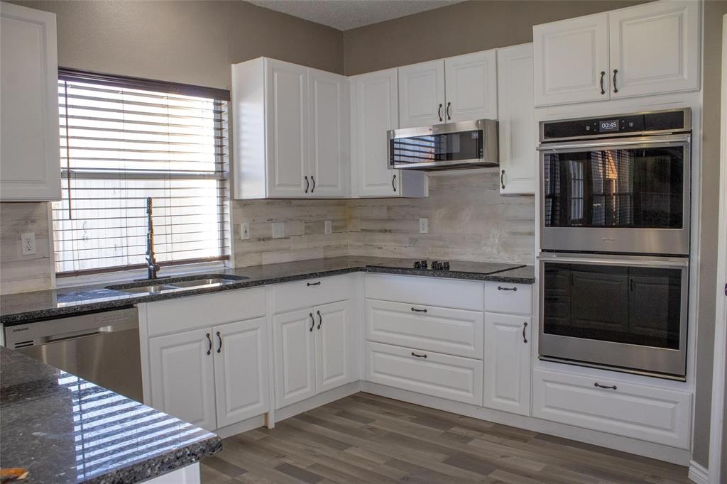 3240 Roddy Drive Fort Worth, TX 76123 - Photo 5 of 28 a kitchen with granite countertop white cabinets and stainless steel appliances