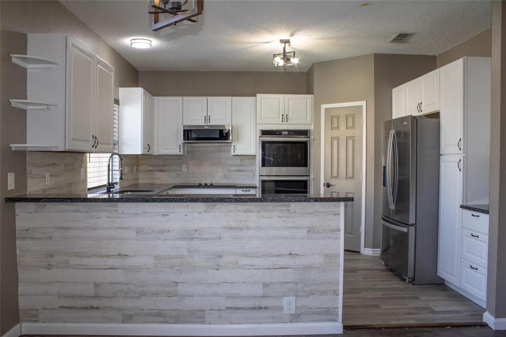 3240 Roddy Drive Fort Worth, TX 76123 - Photo 6 of 28 a kitchen with granite countertop a refrigerator and a stove top oven