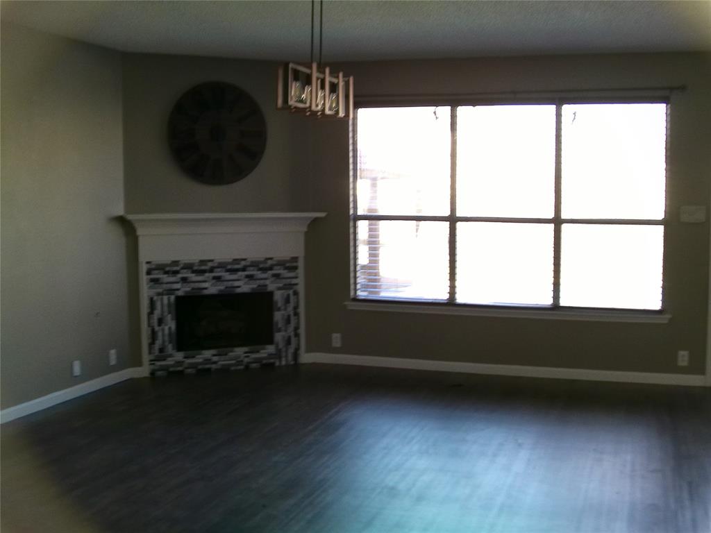3240 Roddy Drive Fort Worth, TX 76123 - Photo 8 of 28 a living room with a fireplace and a floor to ceiling window