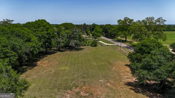 a view of a house with brick walls and a large tree