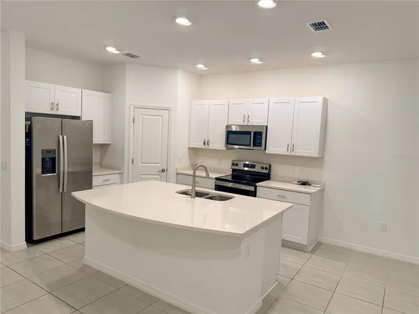 a kitchen with kitchen island sink refrigerator and microwave