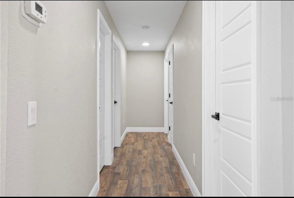 2981 Crane Avenue North Port, FL 34286 - Photo 10 of 16 a view of a hallway with wooden floor and a bathroom