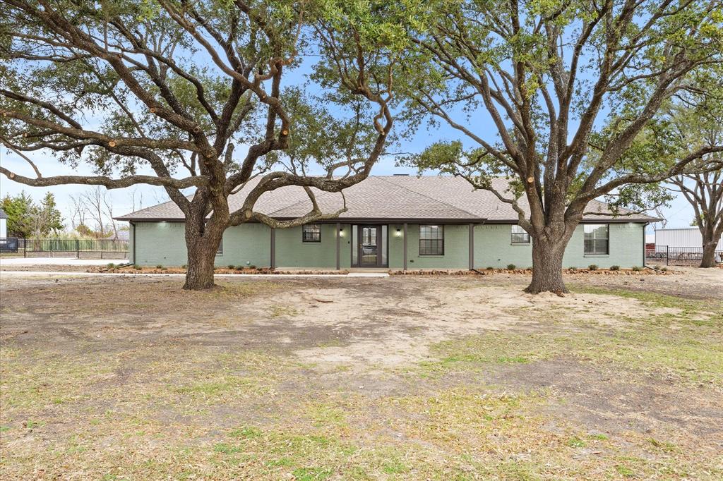 a front view of a house with a yard and trees