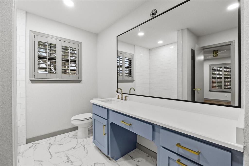 8 Harker Circle Rockwall, TX 75087 - Photo 18 of 29 a bathroom with a sink a toilet a mirror and a window