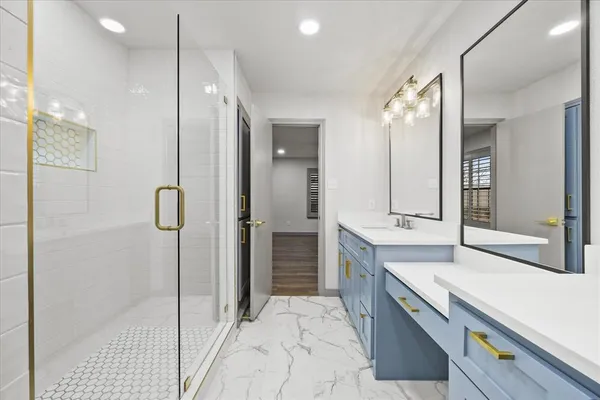 a bathroom with a double vanity sink mirror and shower