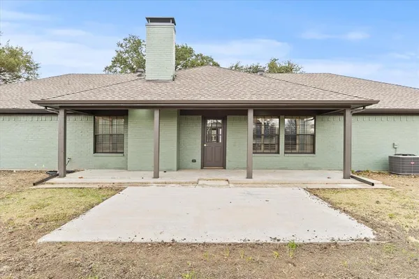 a front view of house with yard and trees around