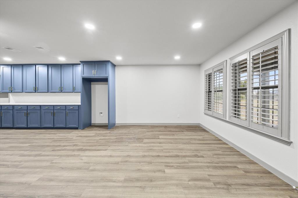 8 Harker Circle Rockwall, TX 75087 - Photo 7 of 29 a view of an empty room with wooden floor and a kitchen