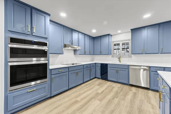 a kitchen with wooden cabinets and stainless steel appliances