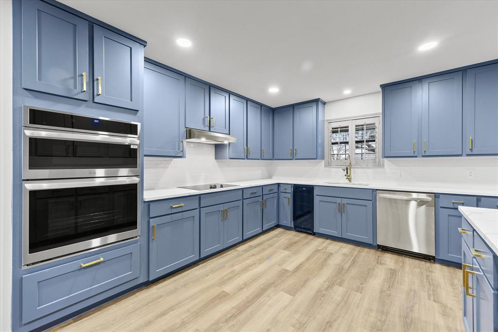 8 Harker Circle Rockwall, TX 75087 - Photo 9 of 29 a kitchen with wooden cabinets and stainless steel appliances