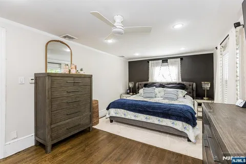 a spacious bedroom with a bed and a dresser