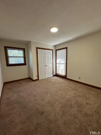 an empty room with windows and closet