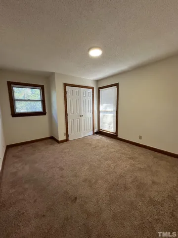 an empty room with windows and closet