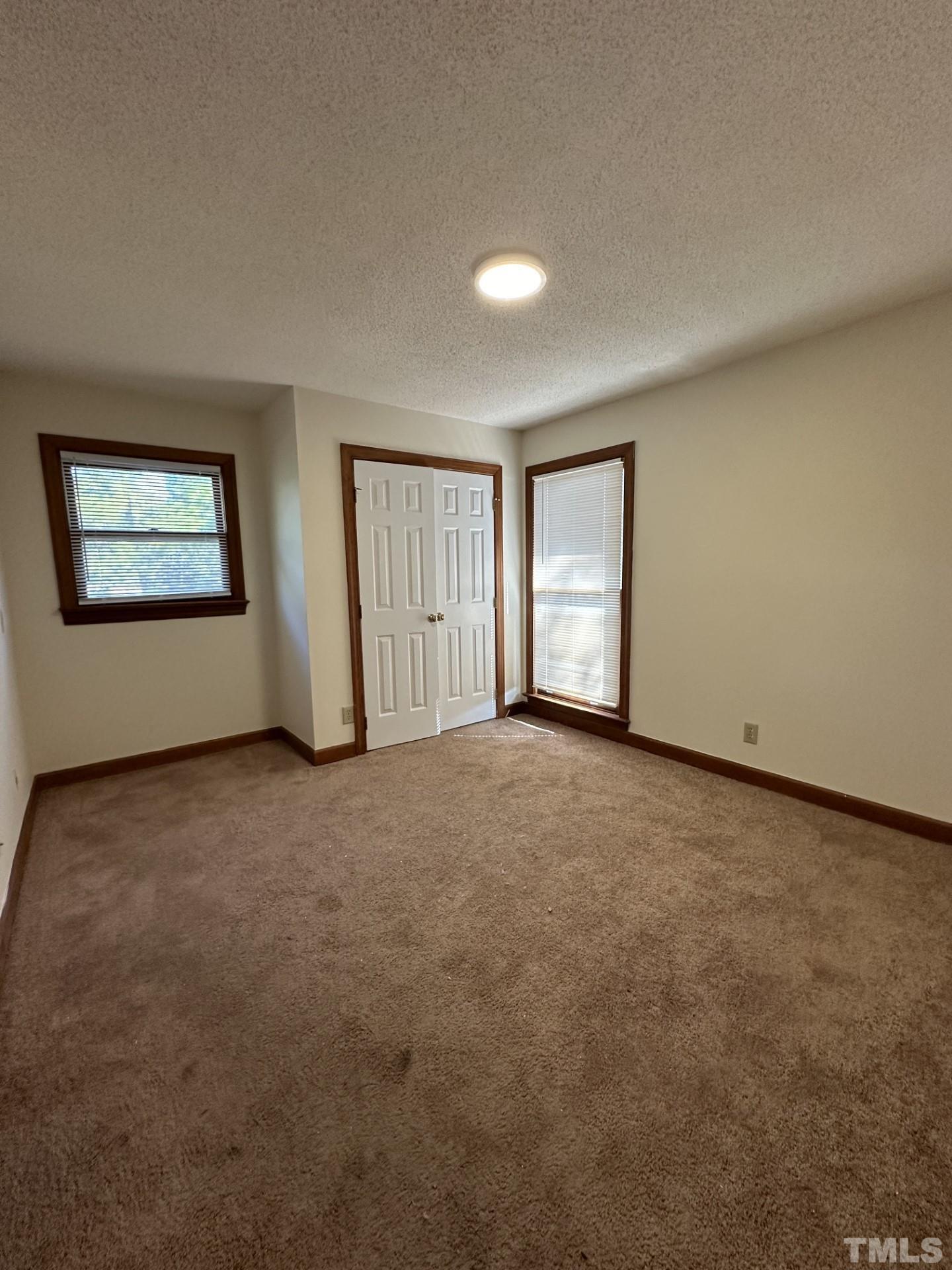 3531 Ivy Commons Drive, Unit 302 Raleigh, NC 27606 - Photo 4 of 4 an empty room with windows and closet