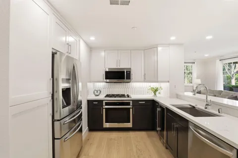 a kitchen with stainless steel appliances a sink stove and refrigerator