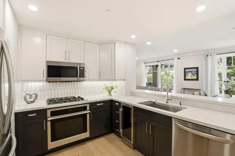 a kitchen with stainless steel appliances a sink dishwasher a stove and a microwave oven