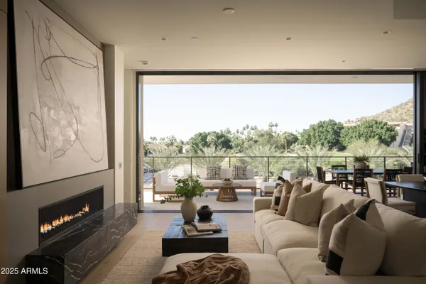 a living room with furniture large window and a fireplace