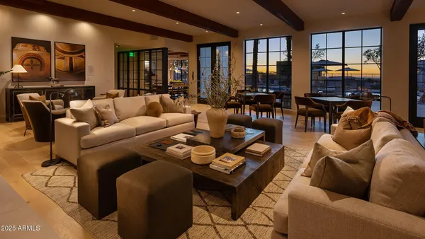 a living room with furniture wooden floor and floor to ceiling window