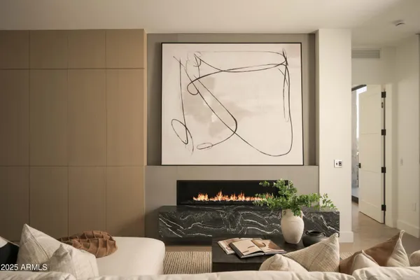 a living room with furniture a fireplace and a floor to ceiling window