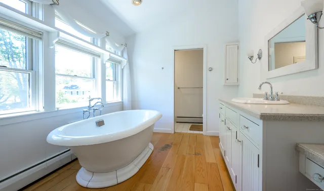 a spacious bathroom with a double vanity sink a mirror and a bathtub