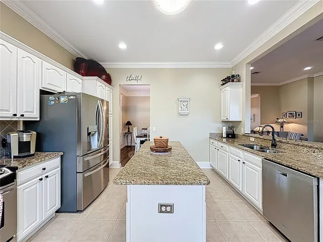 a kitchen with stainless steel appliances granite countertop a stove top oven a sink a microwave and refrigerator