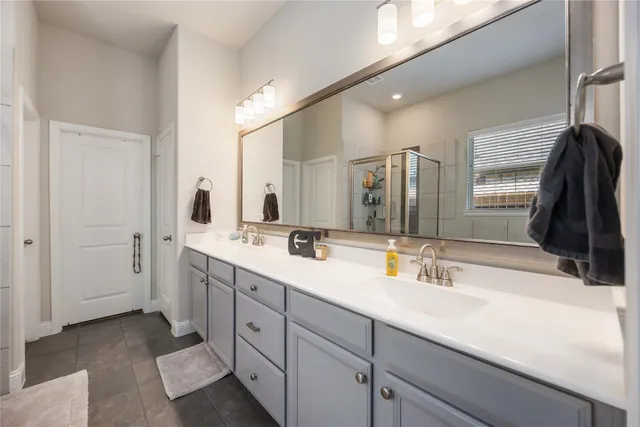 a bathroom with a double vanity sink and mirror