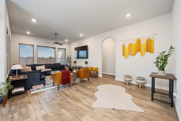 a living room with furniture kitchen view and a large window