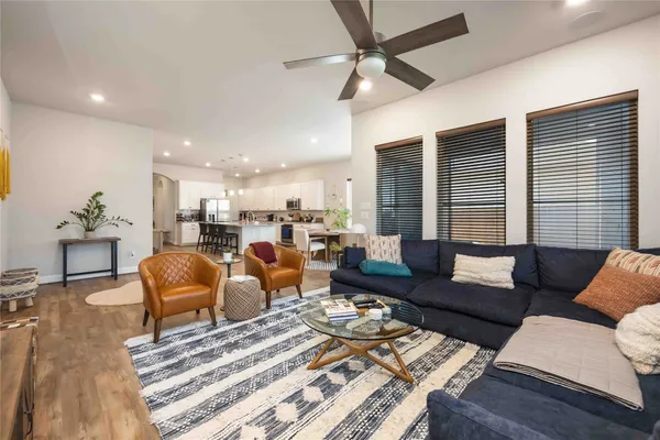 a living room with furniture kitchen view and a window