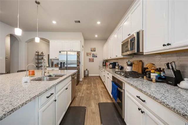a open kitchen with stainless steel appliances granite countertop a sink and cabinets