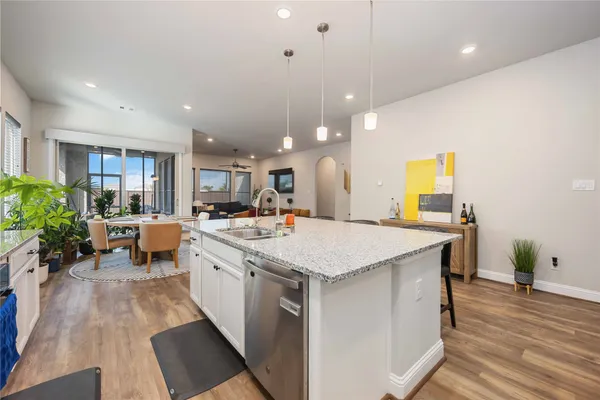 a large kitchen with sink a counter top space and living room view