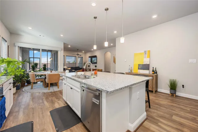 a large kitchen with sink a counter top space and living room view