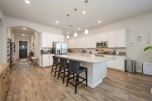 a kitchen with a sink cabinets and wooden floor
