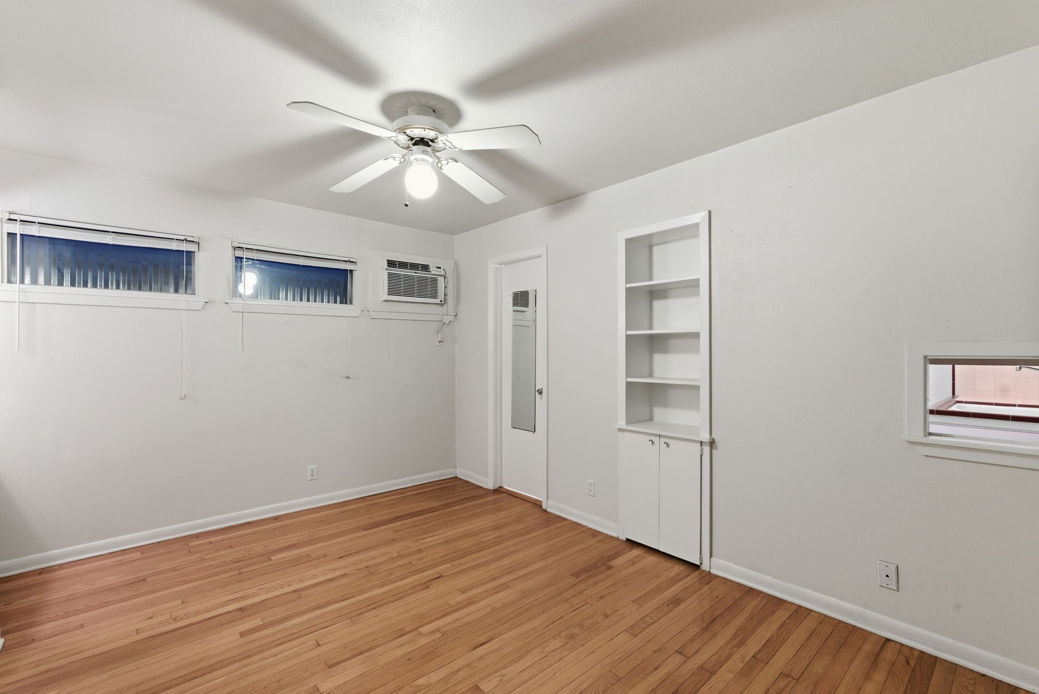 1941 Lexington Street, Unit 6 Houston, TX 77098 - Photo 20 of 50 a view of an empty room with a window and wooden floor