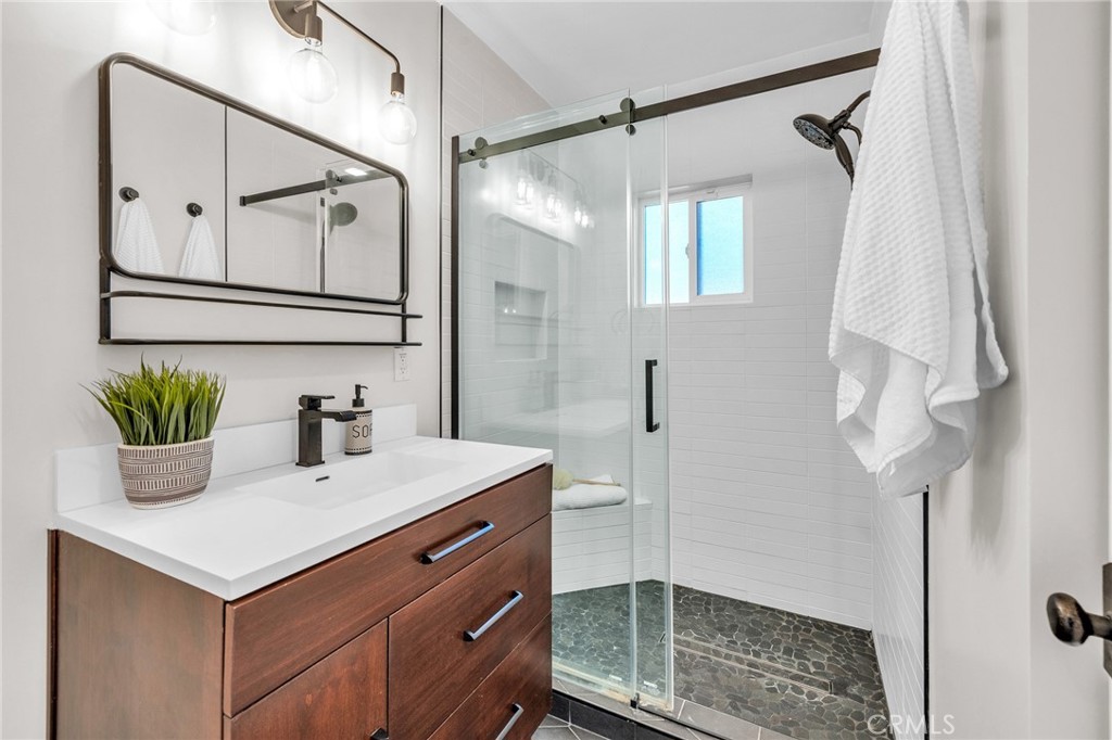 6620 Vesper Avenue Van Nuys, CA 91405 - Photo 15 of 40 a bathroom with a shower sink and mirror