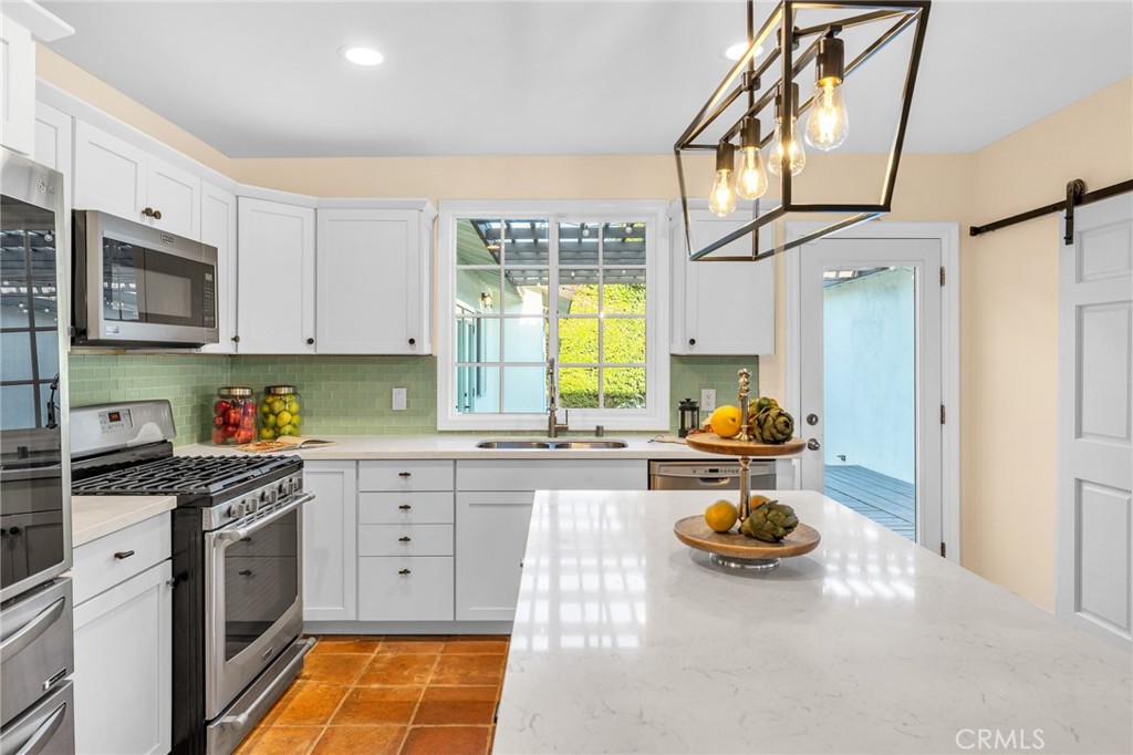 6620 Vesper Avenue Van Nuys, CA 91405 - Photo 10 of 40 a kitchen with a sink a stove and cabinets