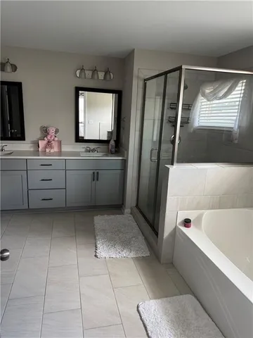 a bathroom with a tub sink and mirror