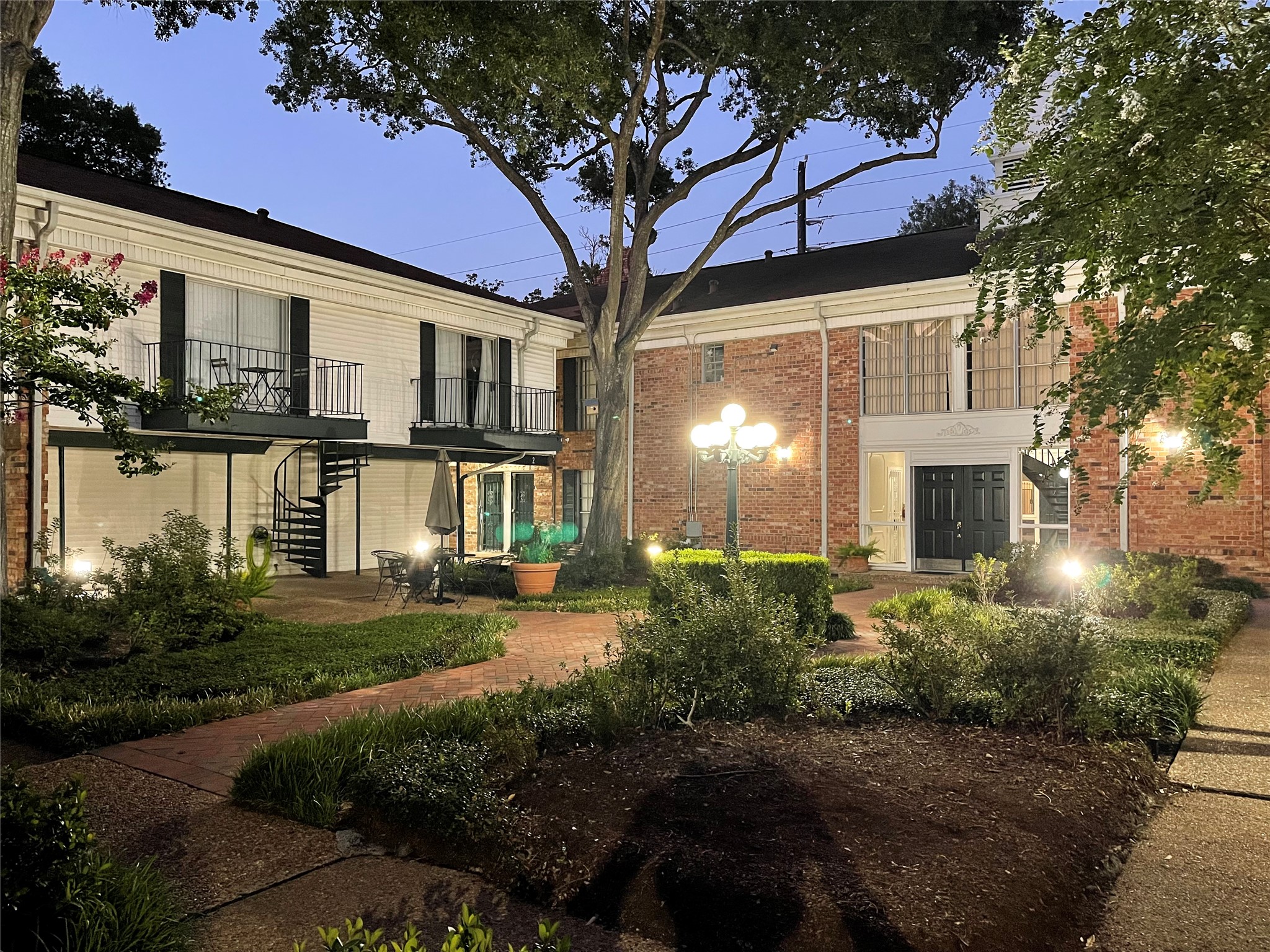 3400 Timmons Lane, Unit 13 Houston, TX 77027 - Photo 3 of 35 a front view of a house with garden and patio