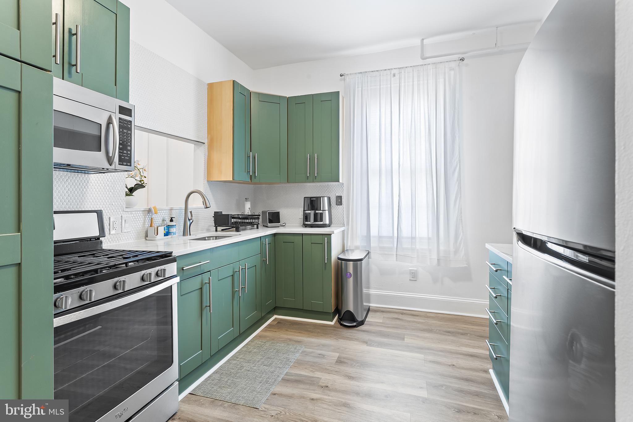 569 North 20th Street, Unit 2F Philadelphia, PA 19130 - Photo 2 of 21 a kitchen with stainless steel appliances a refrigerator sink and stove