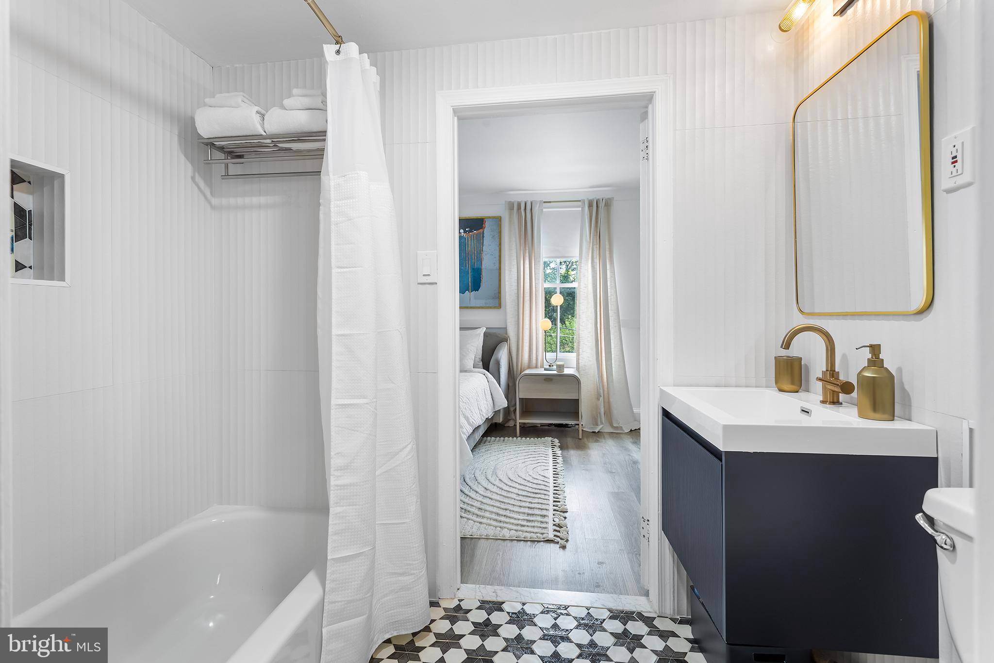 569 North 20th Street, Unit 2F Philadelphia, PA 19130 - Photo 21 of 21 a en suite bathroom with a sink a mirror and a bathtub