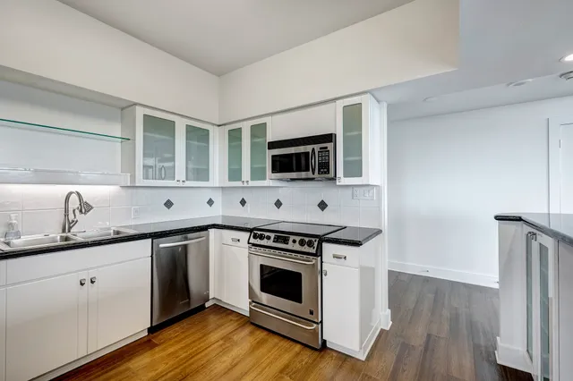 a kitchen with stainless steel appliances granite countertop a stove and a sink