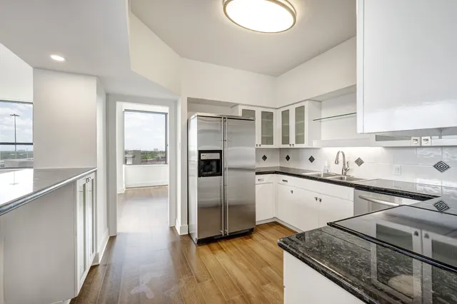 a kitchen with granite countertop white cabinets and stainless steel appliances