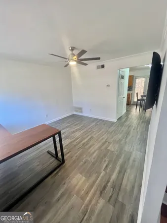 a view of a room with wooden floor fan and window