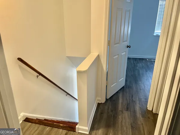 a view of a hallway with wooden floor and staircase