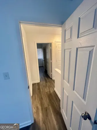 a view of a hallway with wooden floor and staircase