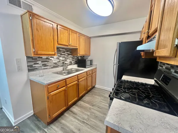 a kitchen with a stove a sink and a refrigerator