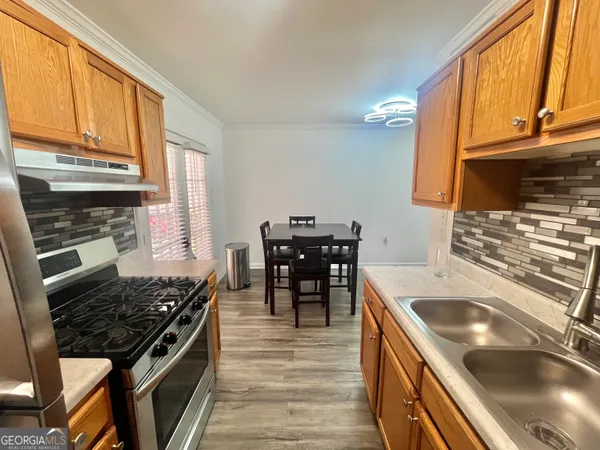 a kitchen with a stove sink and cabinets
