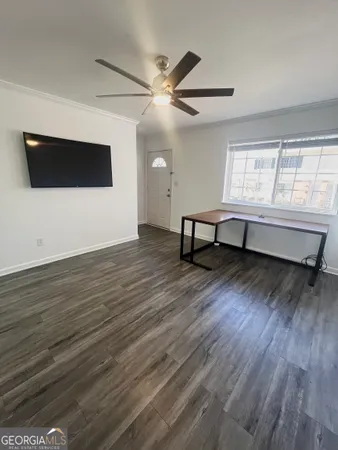 a view of an empty room with wooden floor and a window